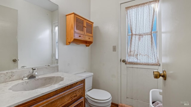 bathroom featuring vanity, toilet, and a wealth of natural light