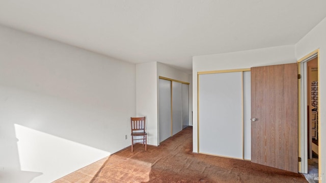 unfurnished bedroom featuring two closets and light colored carpet