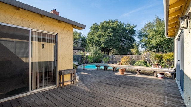 wooden terrace featuring a fenced in pool