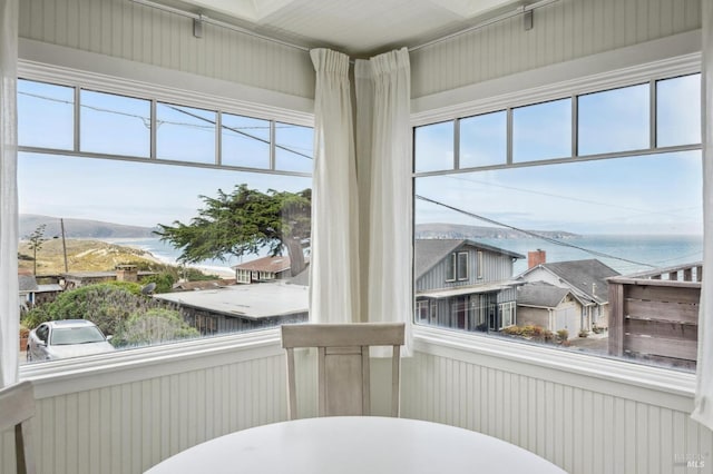 sunroom featuring a water view