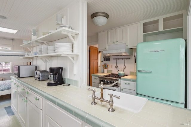 kitchen with white cabinetry, appliances with stainless steel finishes, and tile countertops