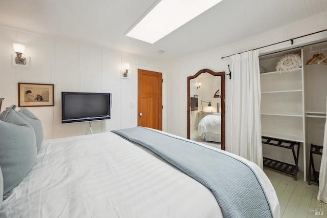 bedroom with light hardwood / wood-style flooring and a skylight