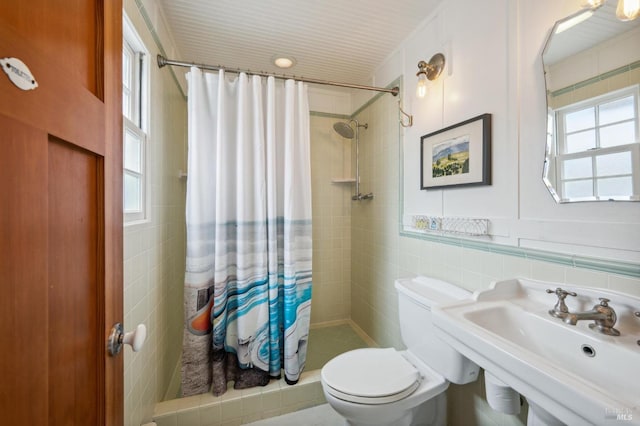 bathroom with toilet, sink, tile walls, and a shower with curtain