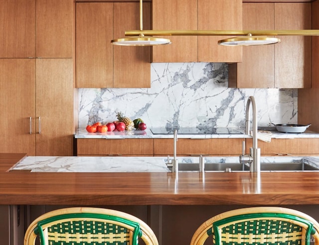 kitchen with brown cabinets, decorative backsplash, and wooden counters