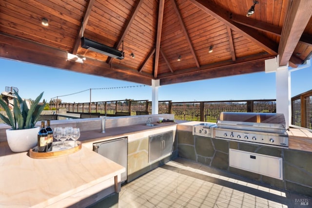 view of patio / terrace featuring area for grilling, sink, a gazebo, and an outdoor kitchen