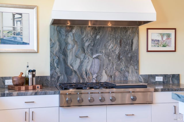 kitchen featuring tasteful backsplash, white cabinets, stainless steel gas cooktop, and exhaust hood