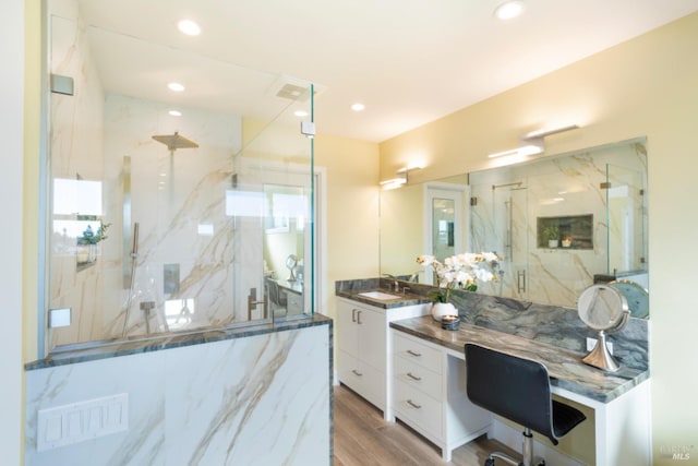 bathroom featuring a tile shower, vanity, and hardwood / wood-style flooring