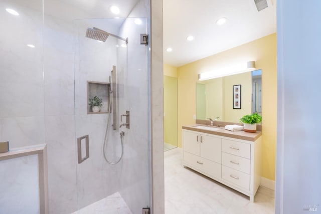 bathroom featuring vanity and a shower with door