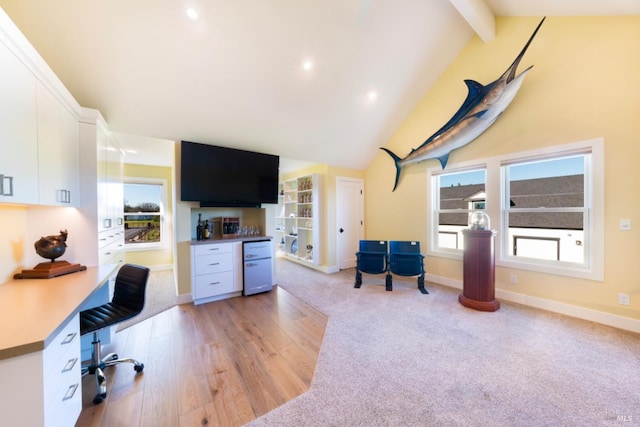 office featuring beam ceiling, high vaulted ceiling, and light hardwood / wood-style flooring