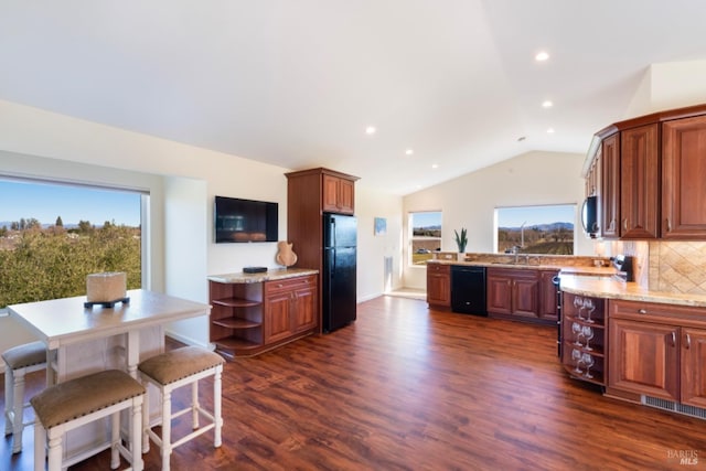 kitchen featuring tasteful backsplash, vaulted ceiling, dark hardwood / wood-style floors, light stone countertops, and black appliances