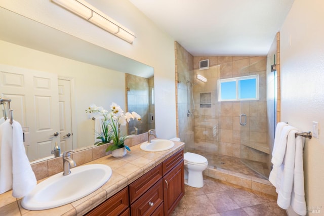 bathroom featuring vanity, toilet, and a shower with shower door