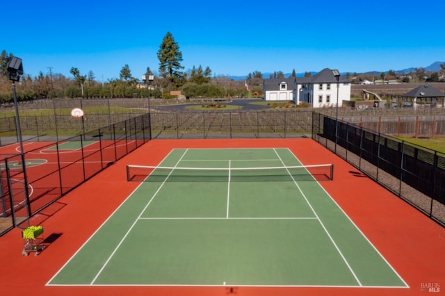 view of tennis court with basketball hoop