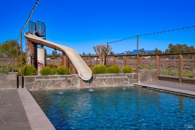 view of pool with pool water feature and a water slide