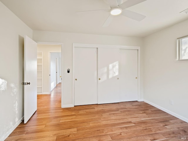 unfurnished bedroom with light wood-style floors, a closet, ceiling fan, and baseboards