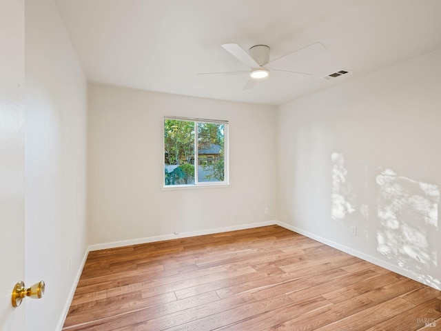 spare room with a ceiling fan, light wood-style flooring, visible vents, and baseboards