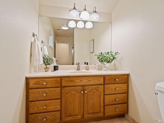 bathroom featuring toilet, visible vents, an enclosed shower, and vanity