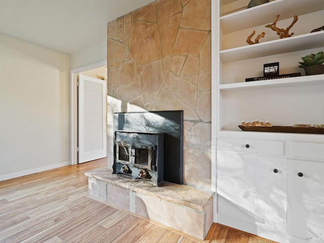 unfurnished living room with built in features, baseboards, and wood finished floors