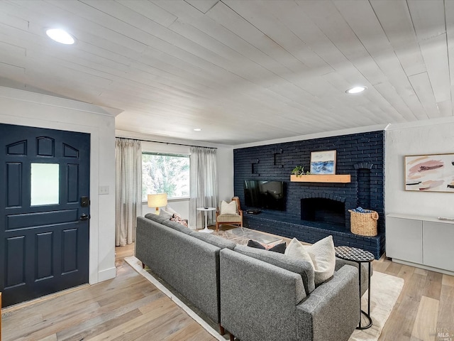 living room with crown molding, wood ceiling, a fireplace, and light wood-type flooring