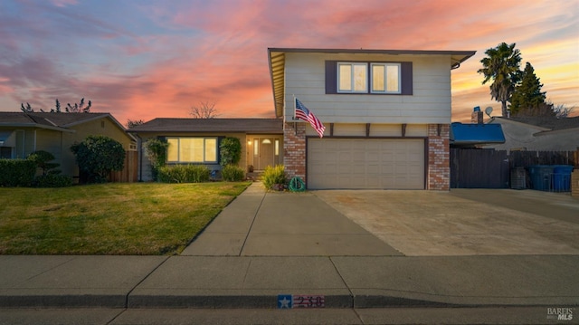 traditional home with a front yard, an attached garage, fence, concrete driveway, and brick siding