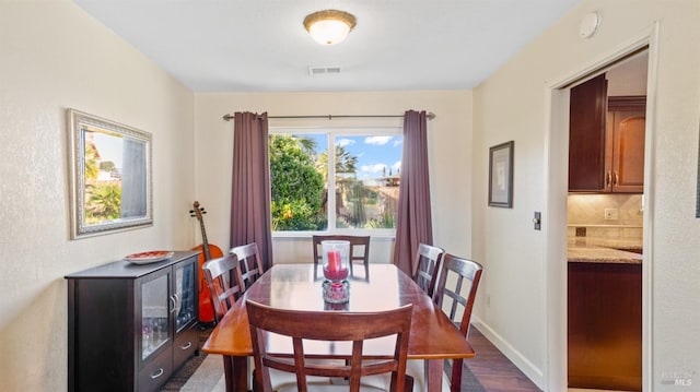 dining space with dark hardwood / wood-style flooring