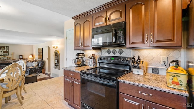 kitchen featuring light stone countertops, light tile patterned floors, decorative backsplash, and black appliances