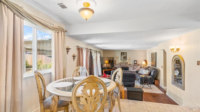 dining area with a healthy amount of sunlight, a fireplace, and light tile patterned floors