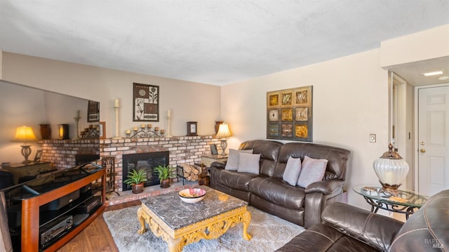 living room with hardwood / wood-style flooring, a textured ceiling, and a fireplace