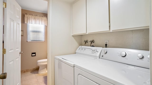 clothes washing area with cabinets, light tile patterned floors, and independent washer and dryer