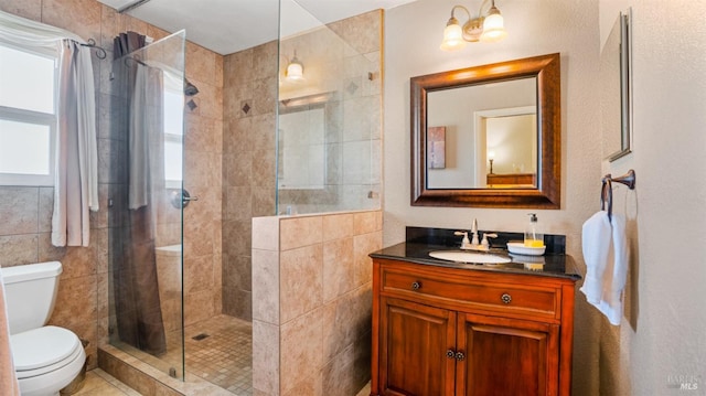 bathroom featuring vanity, toilet, and a tile shower