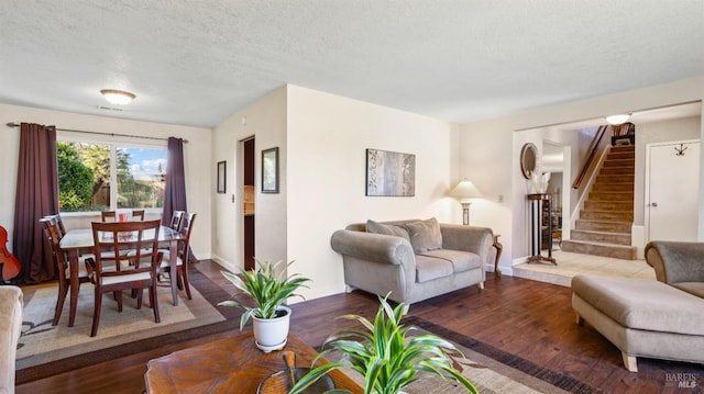 living room with wood-type flooring and a textured ceiling