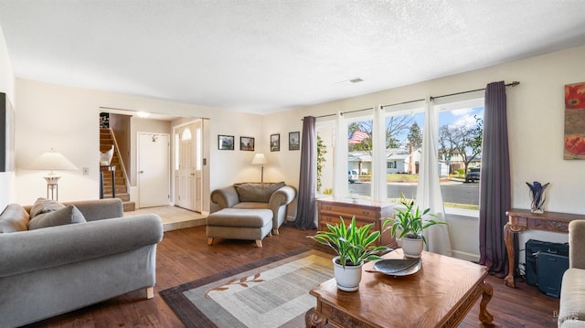 living room with hardwood / wood-style flooring, a fireplace, and a textured ceiling