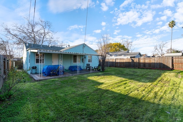 rear view of house with a lawn and a patio area