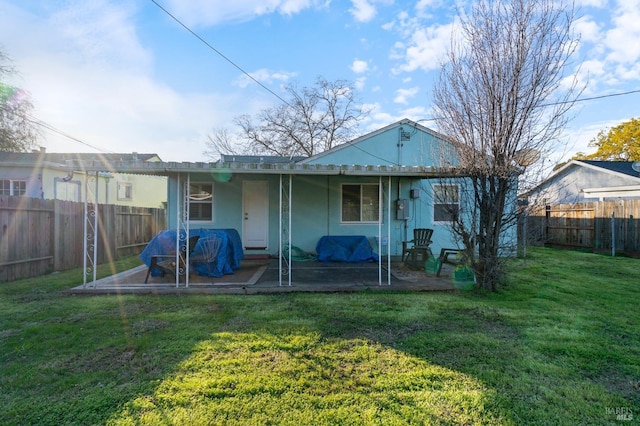 rear view of property featuring a patio area and a lawn