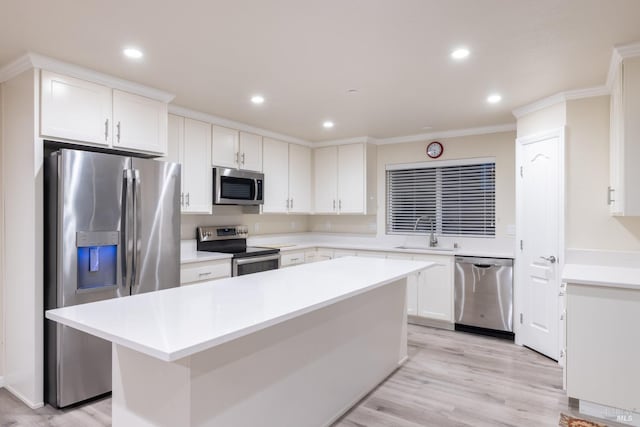 kitchen with sink, stainless steel appliances, a center island, and white cabinets