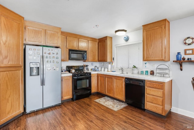 kitchen featuring tile countertops, dark hardwood / wood-style floors, sink, and black appliances