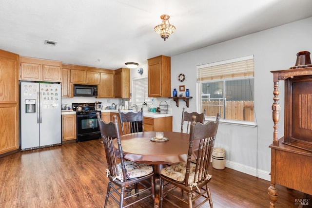 dining area featuring plenty of natural light, dark hardwood / wood-style flooring, and sink