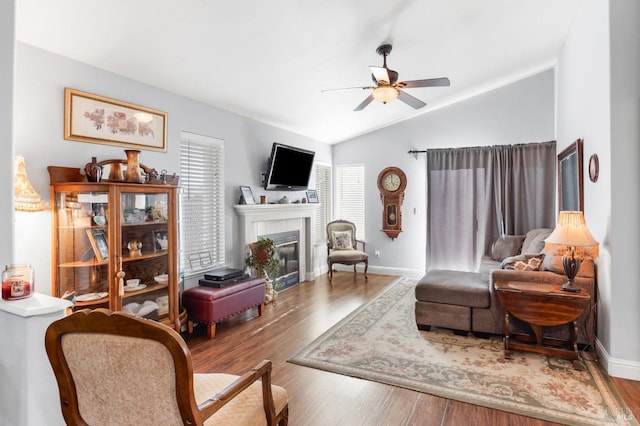 living room featuring vaulted ceiling, wood-type flooring, and ceiling fan