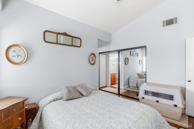 bedroom with hardwood / wood-style flooring, vaulted ceiling, and a closet