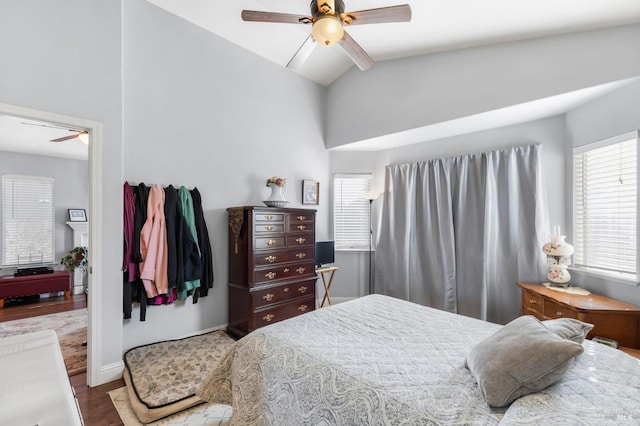 bedroom with multiple windows, hardwood / wood-style floors, vaulted ceiling, and ceiling fan