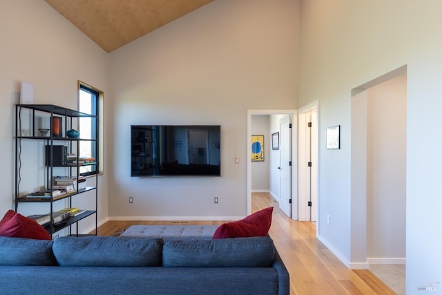 living room with light hardwood / wood-style floors and high vaulted ceiling