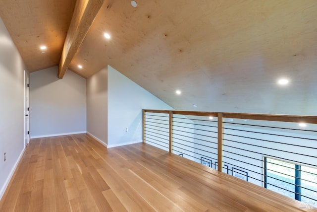 additional living space featuring vaulted ceiling with beams and light wood-type flooring