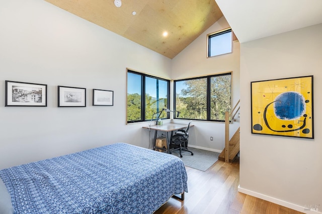 bedroom featuring hardwood / wood-style flooring and high vaulted ceiling