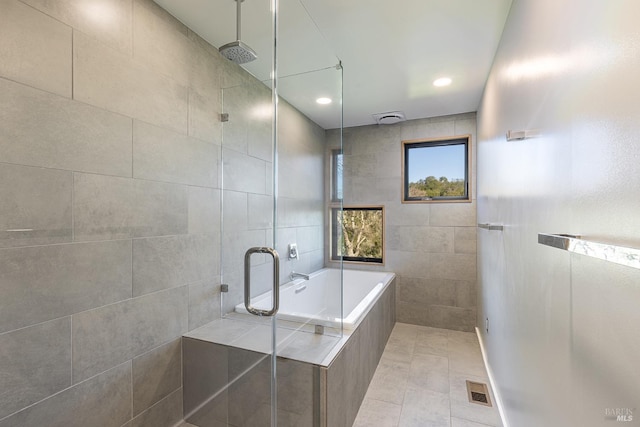 bathroom with tile walls, tile patterned flooring, and plus walk in shower