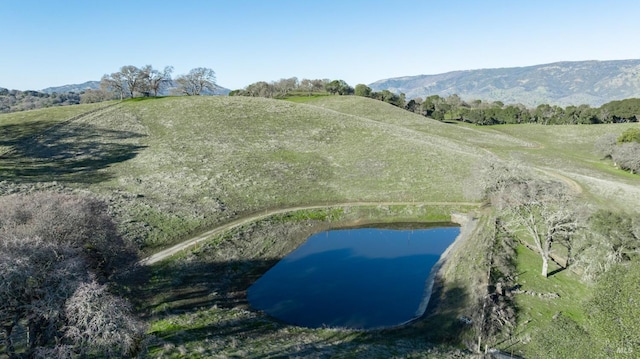 aerial view featuring a water and mountain view and a rural view