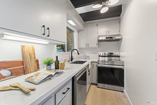 kitchen featuring light stone counters, sink, and stainless steel appliances