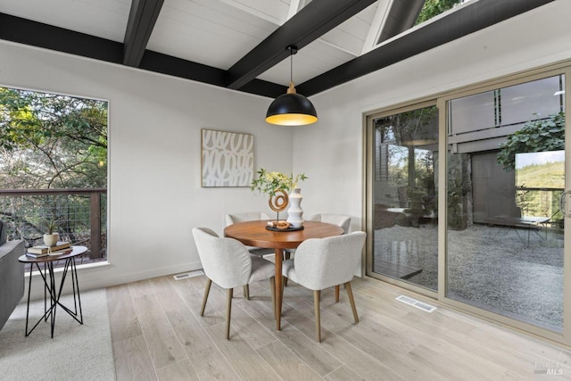 dining room with hardwood / wood-style flooring and beamed ceiling