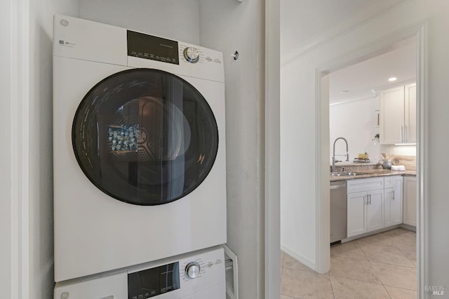 laundry room with stacked washer / dryer, ornamental molding, sink, and light tile patterned floors