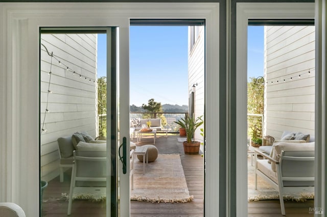 doorway to outside featuring wood-type flooring and wood walls