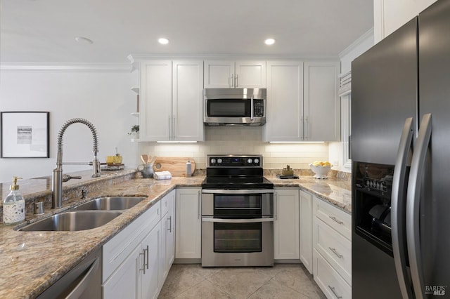 kitchen featuring sink, light tile patterned floors, appliances with stainless steel finishes, light stone countertops, and white cabinets