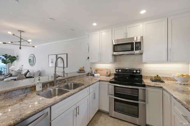 kitchen featuring sink, light tile patterned floors, appliances with stainless steel finishes, light stone countertops, and white cabinets